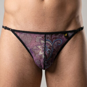 Close-up of a man wearing a purple paisley-patterned thong with black trim and side straps.